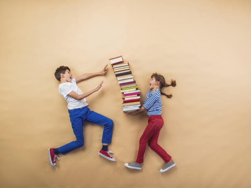To børn med en stak bøger imellem sig
